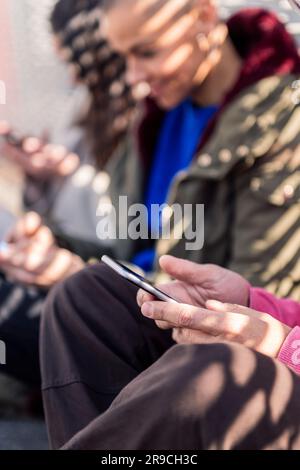 close up of a man using mobile phone with friends Stock Photo