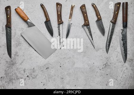 Various types of knives scattered on concrete background Stock Photo