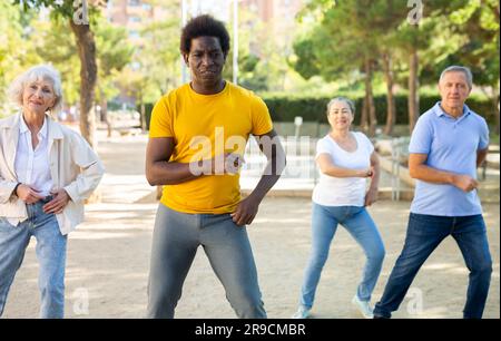 Happy multiracial adult people with different ages having fun doing aerobics outdoor Stock Photo