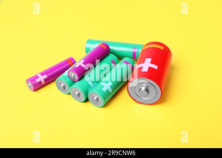 Different types of batteries on yellow background Stock Photo