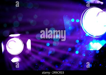 Bright spotlights, beams of light and falling glitter in night club, bokeh effect Stock Photo