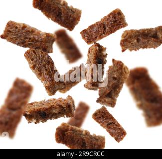 Tasty rye croutons falling on white background, collage design Stock Photo