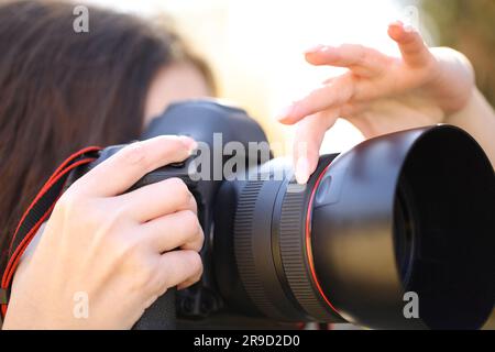 Close up portrait of a photographer hand adjusting focus manually taking photos outdoor Stock Photo