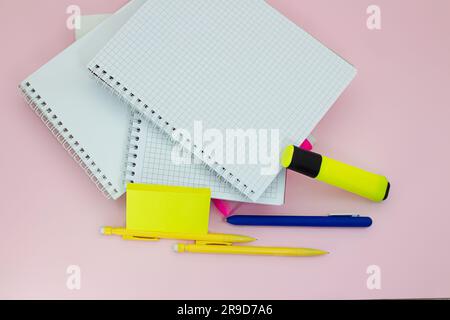 Notebooks with pens, markers and stickers on a pink background. Back to school business meeting. Copy space Stock Photo