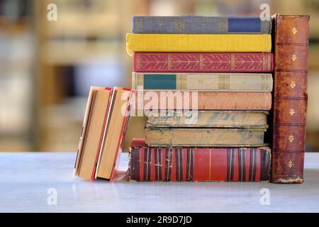 Stack of books with blurred bookshelf background, reading, learning, education or home office concept Stock Photo