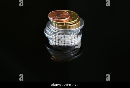 Stuttgart, Germany. 26th June, 2023. ILLUSTRATION - Coins worth 12.41 euros  lie on a black surface (posed