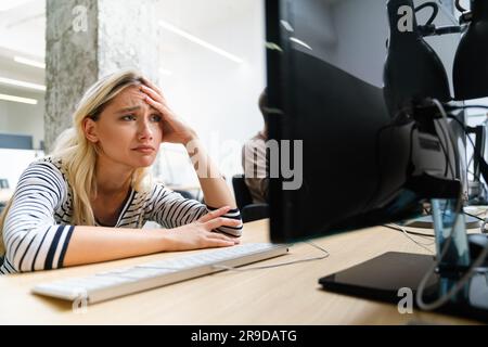 Portrait of a disappointed woman programmer looking stressed out while working on a computer code Stock Photo