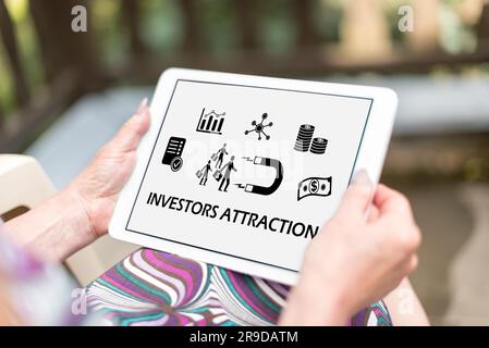 Investors attraction concept shown on a tablet held by a woman Stock Photo