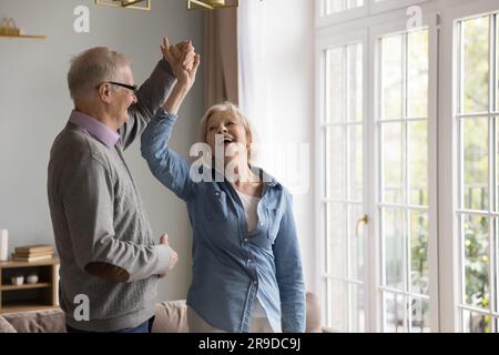 Carefree couple of older retirees dancing at home Stock Photo