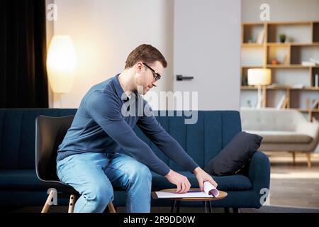 Portrait of happy male psychologist looking at camera and taking notes during therapy session at clinic. Friendly psychotherapist posing and smiling a Stock Photo