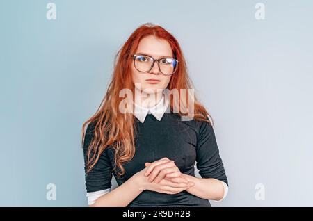 Woman with long red hair in glasses. Teacher. Education, teaching. Librarian Stock Photo