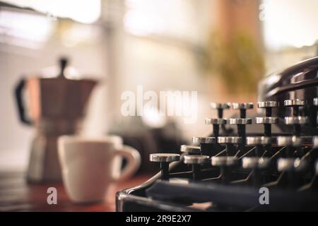 Old. well used typewriter with espresso pot and cup and limited focus Stock Photo