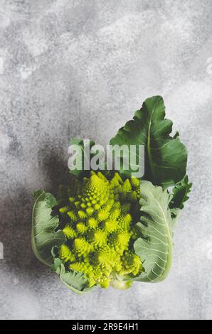 Romanesco broccoli with leaves on grey background with copy space. Stock Photo