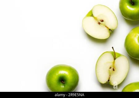 Green whole and sliced apples on white background with copy space. Stock Photo