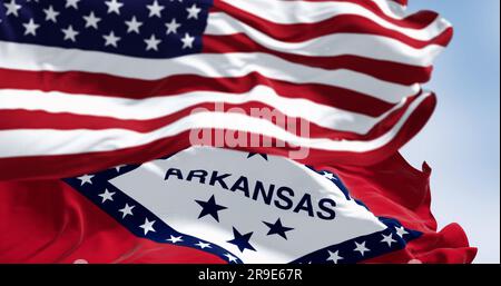 Arkansas state flags waving with the national flag of the United States of America on a clear day. Fluttering fabric. 3d illustration render Stock Photo