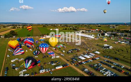 An Aerial View Of Many Hot Air Balloons Launching and Floating Away During a Balloon Festival on a Beautiful Summer Afternoon. Stock Photo
