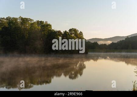 Steam rises over the small pond at scenic Sweetgrass development in Western North Carolina near Blowing Rock, NC on a summer morning. Stock Photo