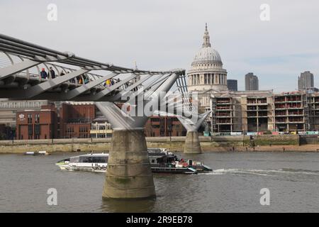 Uber boat passing under Millennium Bridge with St Pauls Cathedral London April 2022 Stock Photo