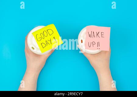 Disposable paper cups with inscriptions Good day and Wake up, top view ...