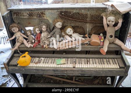 Interior decoration of abandoned private houses with piano and dolls in the exclusion zone of Belarus Stock Photo