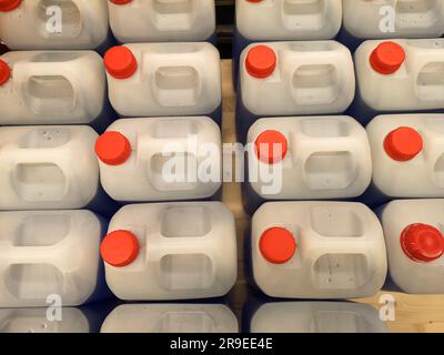 A selection of plastic containers sorted in a row with red caps. Stock Photo