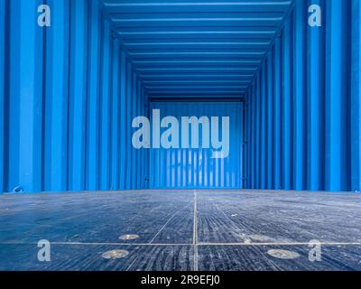 Blue interior of an empty metal shipping container. Shot from the ...