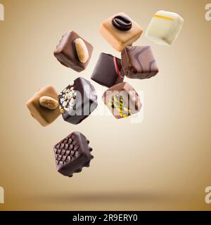 Assorted chocolate pralines floating on brown background Stock Photo