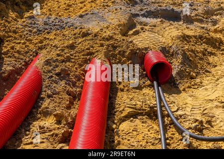 Red plumbing pipe close-up. Drainage, tubing, pipes. Red pipes of the water supply and heating system. Installation of a water supply system in a coun Stock Photo