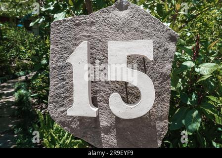 House number 15 installed on a big rock in the garden of residence Stock Photo