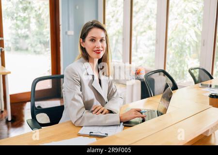 Businesswoman using laptop meeting with partners in modern office Stock Photo