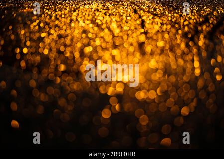 Orange bokeh lights on a car hood at night time as an abstract background Stock Photo
