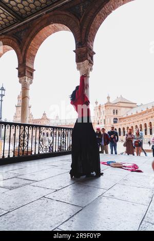 Seville, Spain - Feb 24, 2022: Street artist performing flameco art with dancing and live music at the Plaza de Espana in Seville, Andalusia, Spain.