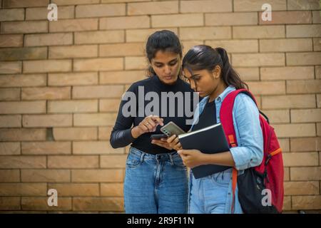 College students looking at their phone and tensed about their result Stock Photo