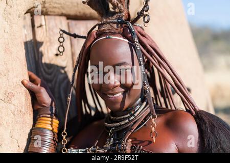 Happy Himba woman smiling, dressed in traditional style at her village in Namibia, Africa. Stock Photo