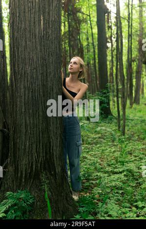 girl teenager in a deciduous grove communicates with trees Stock Photo