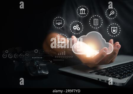 Man holding a laptop displaying cloud computing diagram with financial analytics Stock Photo