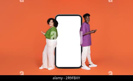 Cheerful young interracial couple using cell phones Stock Photo