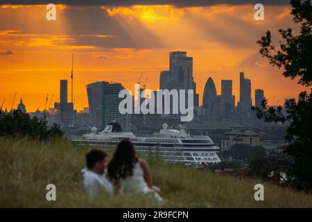 London, UK. 25th June 2023. UK Weather: City Heatwave sees locals enjoy a stunning Sunday evening sunset from top of Greenwich Park ending one of the hottest days of the year so far. Met Office reported the mercury reaching 32.2C at Coningsby, Lincolnshire, on Sunday afternoon - matching the high reached at Chertsey, Surrey, on 10 June. Credit: Guy Corbishley/Alamy Live News Stock Photo