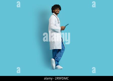 Happy young indian doctor using digital tablet, copy space Stock Photo