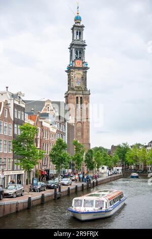 tour boat on the Prince's Canal and Westerkerk Church Tower in Amsterdam Stock Photo