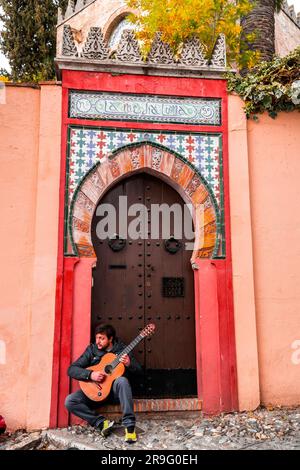 Granada, Spain - February 26, 2022: Young guitar player performing in the streets of Granada, Spain. Stock Photo