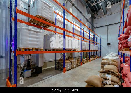 Bags with production on shelves in warehouse. Bags with coffee beans or sugar or other. Stock Photo