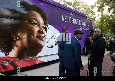 Atlanta, Georgia, USA. 18th Oct, 2022. Pictured: Several men supporters discuss campaign progress as they wait for Stacey Abrams to emerge from her new campaign tour bus. Observers said black male voters are critical if Abrams is to win against incumbent Brian Kemp. Credit: Robin Rayne/ZUMA Wire/Alamy Live News Stock Photo