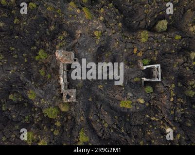 The ruins at Paricutin Volcano situated on a rocky landscape surrounded by lush greenery Stock Photo