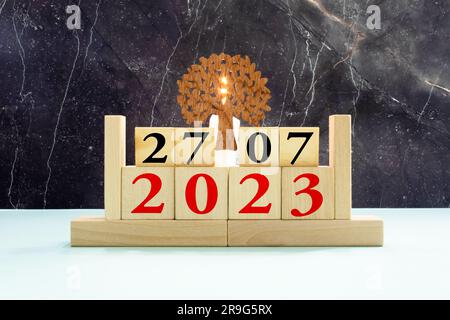 Cube wooden calendar showing date on 27 July. Wooden calendar with date on the table. blur objects on background. Stock Photo