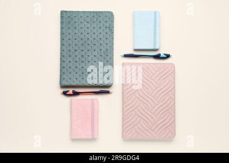 Composition with different notebooks and pens on light background Stock Photo