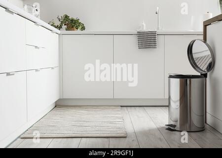 Opened trash bin in interior of light kitchen Stock Photo