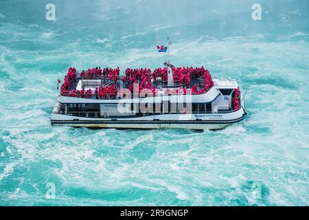 Niagara Falls boat tours attraction. Tourist people sailing on the travel boat close to the Niagara Horseshoe Fall at summer day. Niagra Falls-June 15 Stock Photo