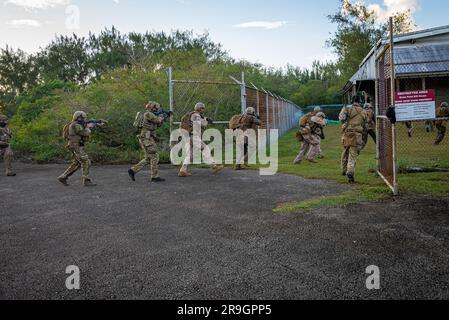 NAVAL BASE GUAM, Guam. (May 11, 2023) –Sailors from Explosive Ordnance Disposal Mobile Unit Five, assigned to Commander. Task Force (CTF) 75, EOD Marines assigned to the 9th Engineering Support Battalion and officers from the Guam Police Department conduct a raid drill and simulated casualty evacuation onto an MH-60S Sea Hawk helicopter assigned to the “Blackjacks” of Helicopter Sea Combat Squadron Two-One (HSC) 21 during a field training training exercise near Naval Base Guam. This training exercise strengthens readiness in inserting personnel into a military area of operations. CTF 75 execut Stock Photo