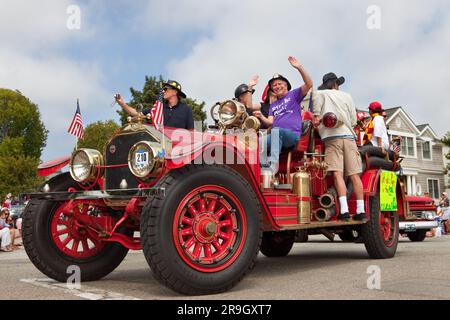 An antique firetruck driving in a 4th of July parade Stock Photo